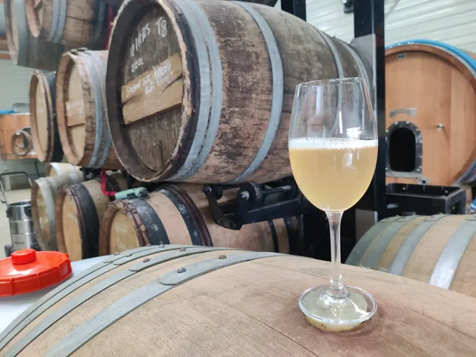 A glass of beer standing on a cask